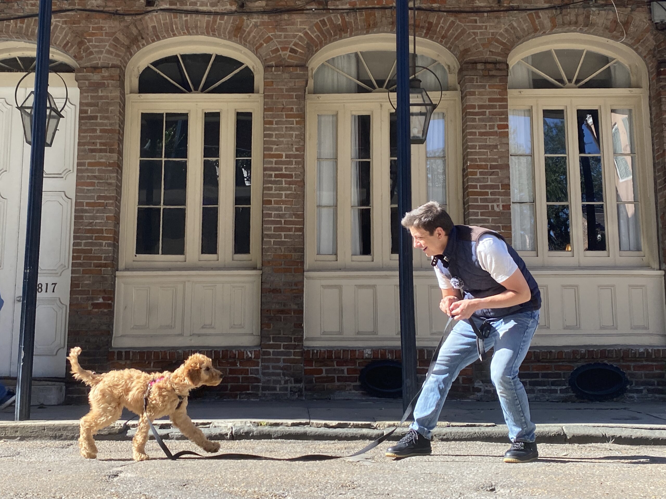 Zak working with Kona on a sidewalk